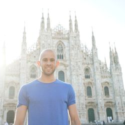 Low angle portrait of smiling man standing against milan cathedral