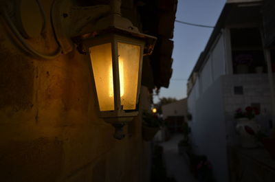 Close-up of illuminated street light in town at dusk