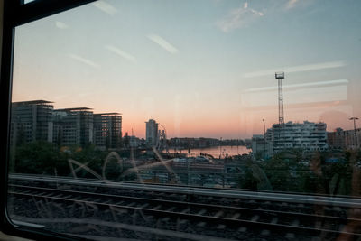 View of bridge and buildings against sky at sunset