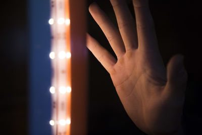 Cropped image of person hand by lighting equipment