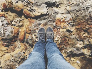 Low section of person standing on rocks at beach