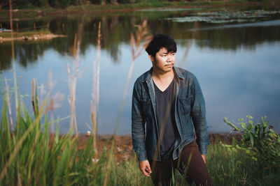 Young man standing at lake