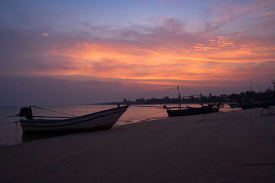 Boats moored on sea against sky during sunset