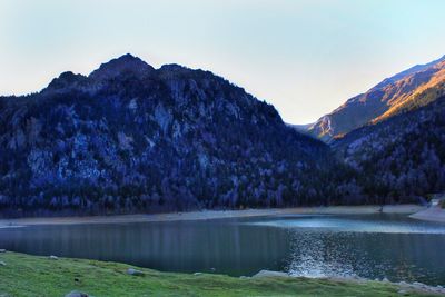 Scenic view of lake and mountains against clear sky