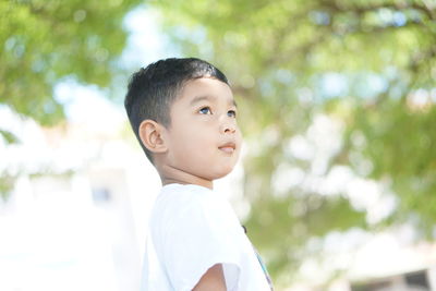 Portrait of cute boy looking away outdoors