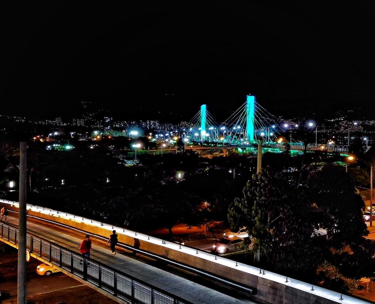 ILLUMINATED SUSPENSION BRIDGE AGAINST SKY AT NIGHT