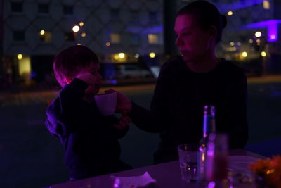 Close-up of mother and daughter on table at night