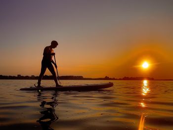 Surfing at sunset. sup board 