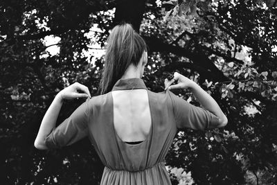 Woman standing on tree trunk