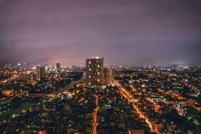 High angle view of illuminated buildings against sky at night