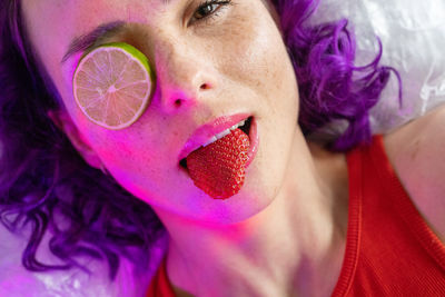 Portrait of woman eating strawberry