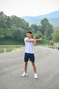 Full length of woman exercising on road