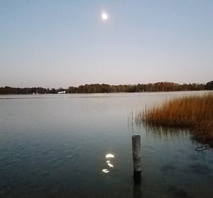 Scenic view of lake against clear sky at night