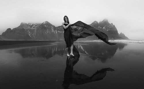 Stylish woman with waving cave on beach monochrome scenic photography