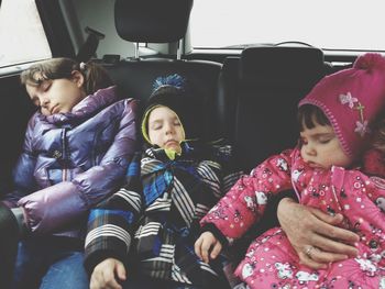 Mother and daughter sleeping in car