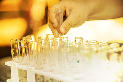Close-up of hand holding test tube over rack in laboratory