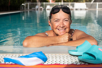 Portrait of smiling mid adult man swimming in pool