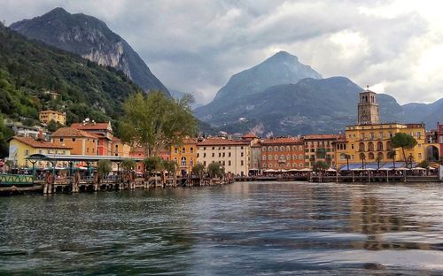 Buildings at waterfront against mountain