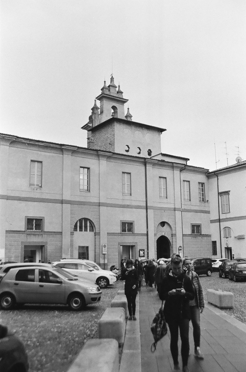 PEOPLE ON STREET BY BUILDING AGAINST SKY