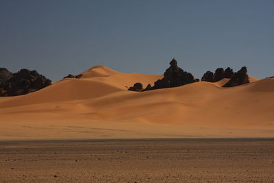 Scenic view of desert against clear sky acacus mountains, libya