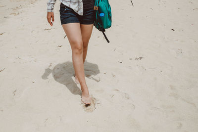 Low section of woman walking on beach