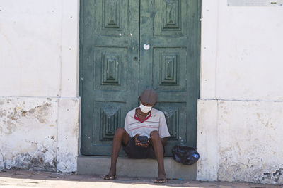 Full length of woman sitting outside house