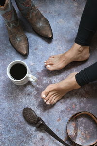 Low section of woman by coffee cup on floor