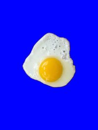 Close-up of yellow egg against blue background