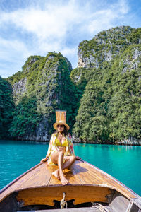 Man sitting on boat against sky