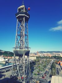 Ferris wheel in city against blue sky