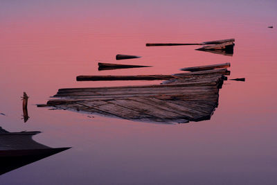 Boats moored at beach against sky during sunset