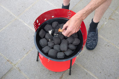 A man lights a fire with a lighter special charcoals for a barbecue