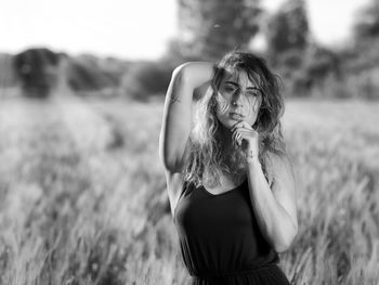 Portrait of young woman standing on field