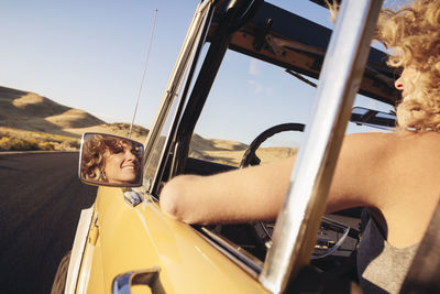 Cropped image of cheerful woman in off-road vehicle