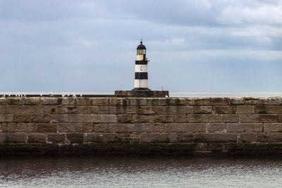 Iconic striped seaham lighthouse in the middle of a sea wall