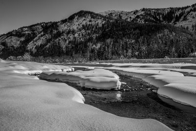 Scenic view of lake against mountain during winter