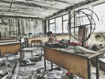 Woman sitting in abandoned building