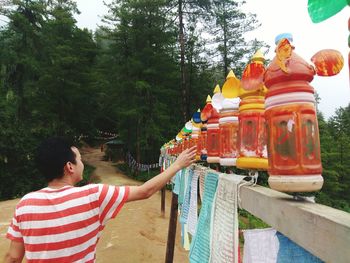 Rear view of man rolling prayer wheels at temple