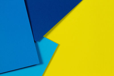 Close-up of yellow paper against blue background