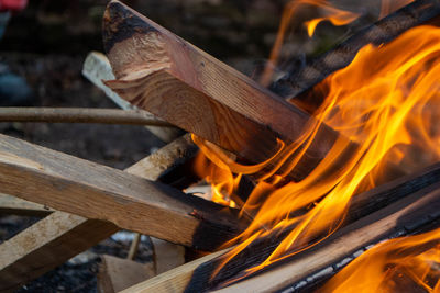 A fire burns in a campfire with a red fire in the background.