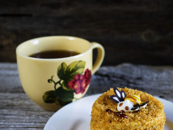 Close-up of cake by tea in cup on wooden table