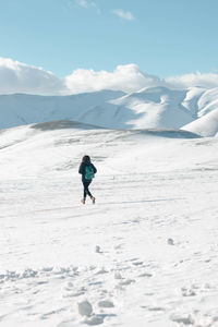 Full length of man on snowcapped mountain against sky