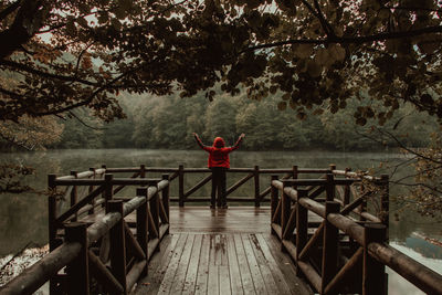 Woman standing on pier by footbridge