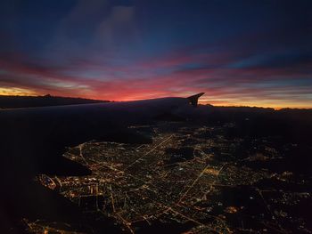 Aerial view of illuminated city during sunset