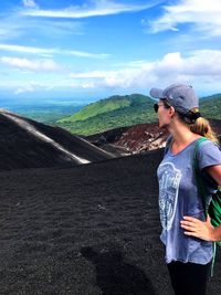 Full length of mature woman with backpack on mountain against sky