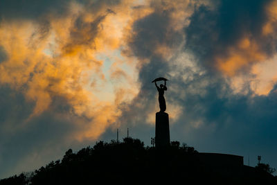 Low angle view of statue against cloudy sky