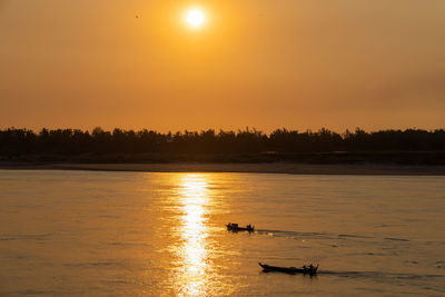 Fisherman on the traditional boat on the mekong river in cambodia during sunset