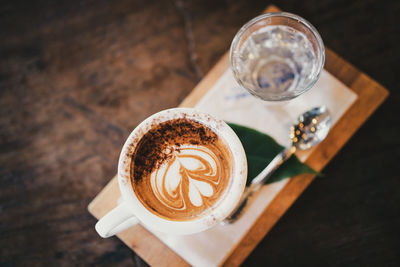 High angle view of coffee with drinking water on wooden table