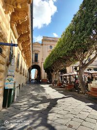 Street amidst buildings in city against sky