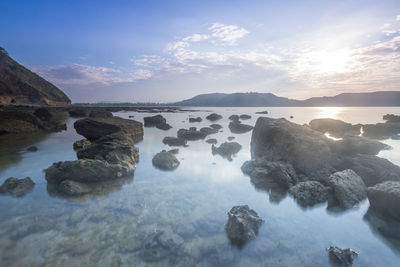 Rocks in sea against sky